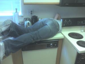 Jess crawling behind stove